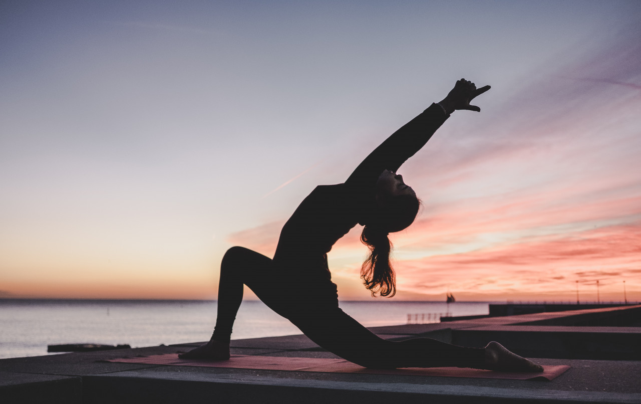 *yoga*  une femme en posture de yoga au coucher du soleil